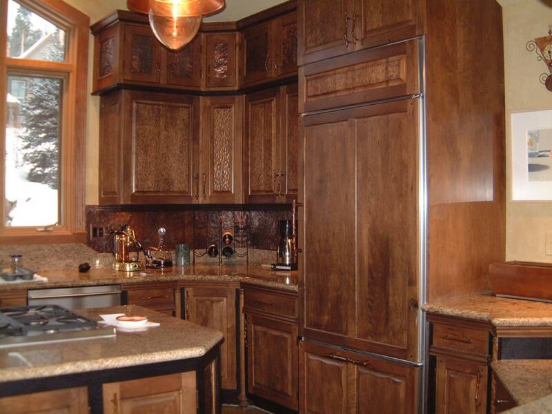 Cherry kitchen with custom cabinet doors, appliance panels and hammered copper backsplash