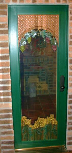 Carved wine cellar door with grape vines and mustard flowers
