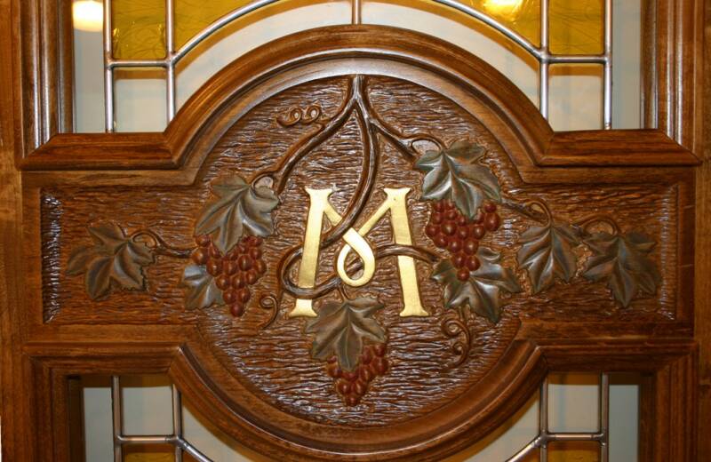 Carved grapes and leaves with gold initial