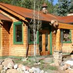 Rustic cabin exterior with carved beam ends, bird houses, character logs