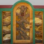 Carved rustic curve top entry door with stained glass