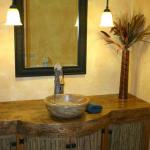 Five inch thick distressed knotty pine top supports a stone vessel sink with a touch controlled faucet. The curved and straight doors are in-filled with bamboo to create a "green" vanity.