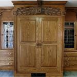 Solid oak entertainment center with personalized carving, stained glass and media storage.
