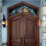 Solid cherry double entry doors with stained and leaded glass transom.