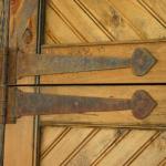 Rusted metal hardware on a rustic beadboard and pine door