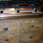 Drawer fronts made from reclaiimed wood below the gas cooktop