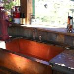 Handmade copper farm sink and antique pump faucet.