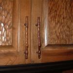 Close up view of cherry gouged raised panel cabinet doors and custom hardware