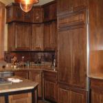 Cherry cabinets with hammered copper panels and custom appliance panels.