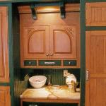 Carved cabinet doors hide microwave near baking center